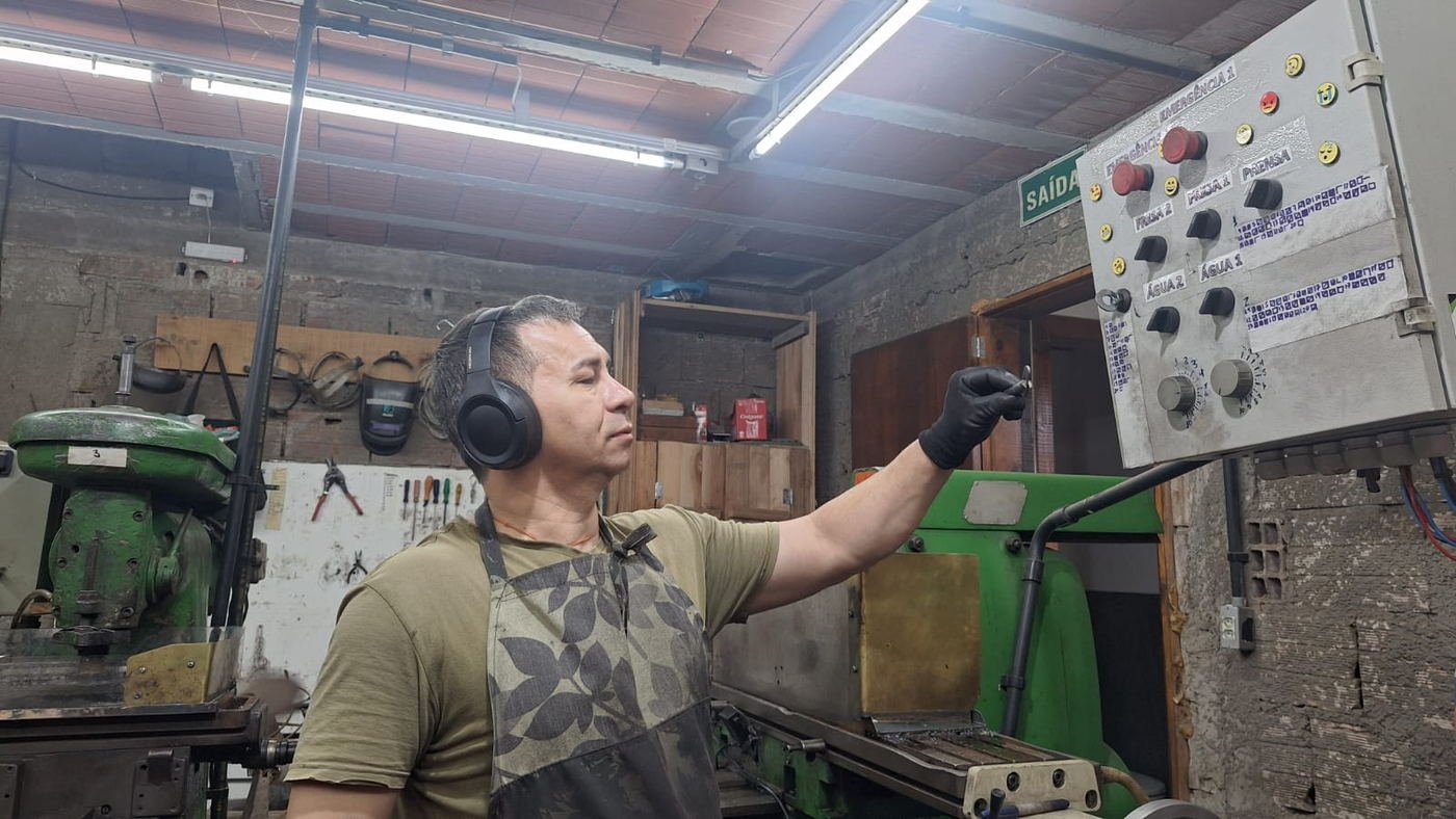 Operador da Astro Ferro acionando o painel da prensa na fábrica em Taquari (RS)